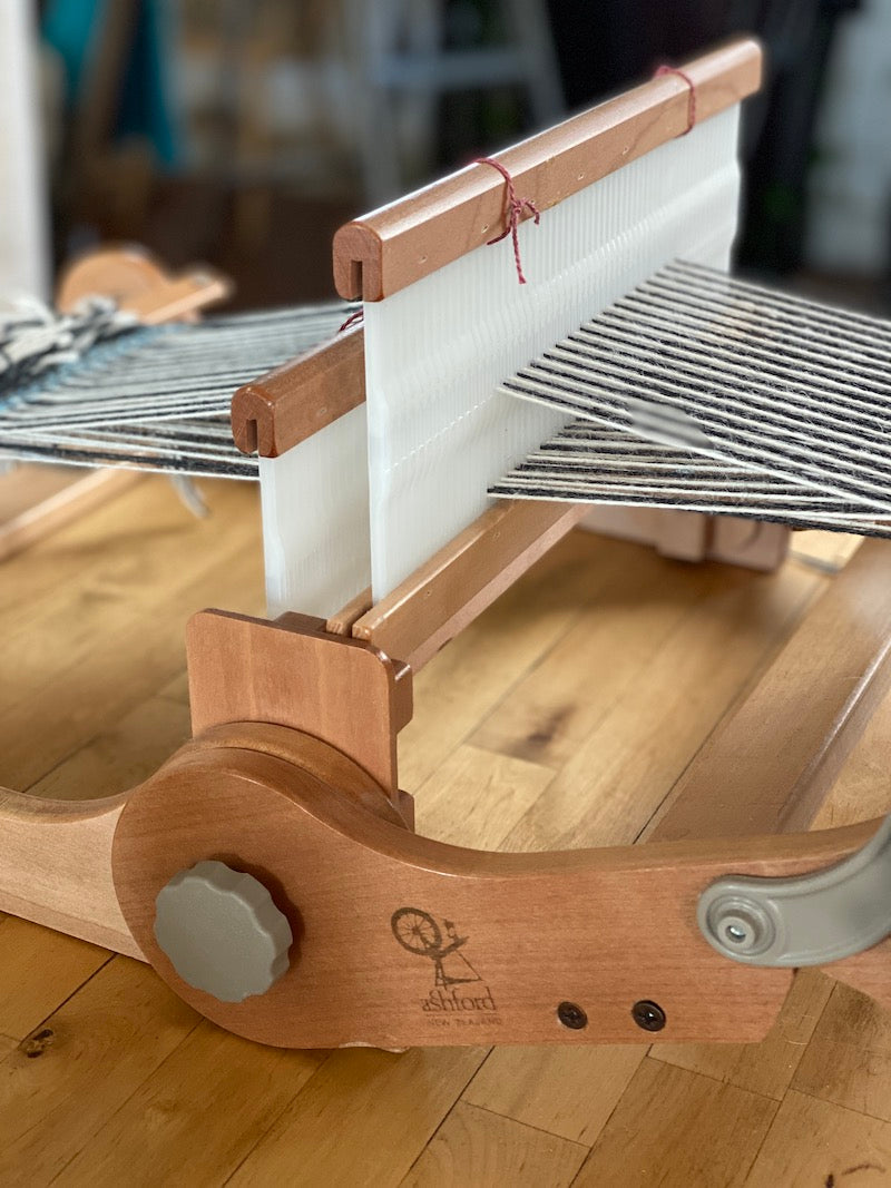 An Ashford loom warped with black and white yarns with Heddle 2 up. 